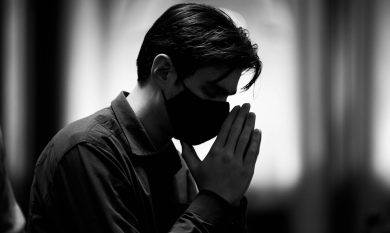 man in black leather jacket covering his face