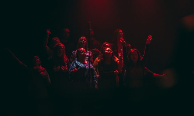group of person singing on dark ara